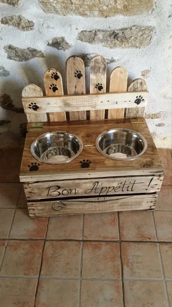 Comedero de madera con dos recipientes de acero y huellitas pintadas