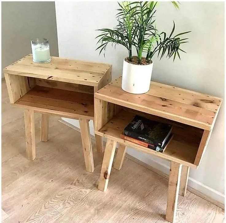 Dos mesas de luz de madera clara con patas, una con una planta y otra con libros