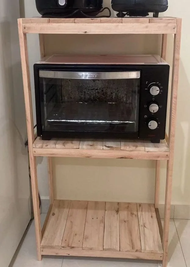 Mueble de madera clara con tres estantes que sostiene un horno eléctrico