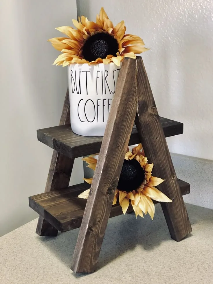 Soporte de madera oscura de dos niveles con una taza y girasoles