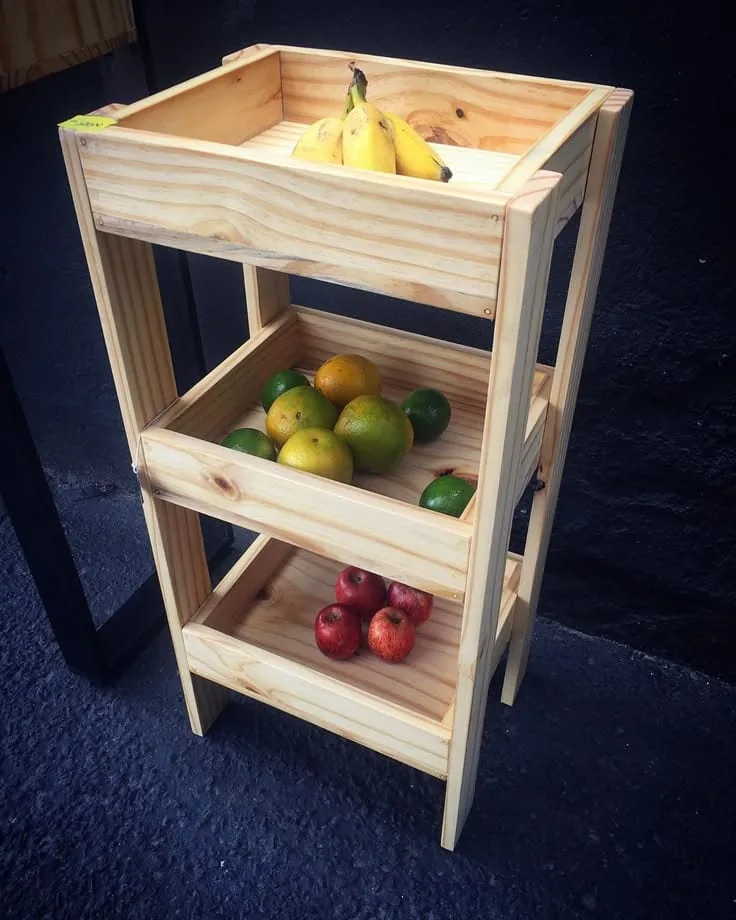 Verdulero de madera clara con tres cajones llenos de frutas