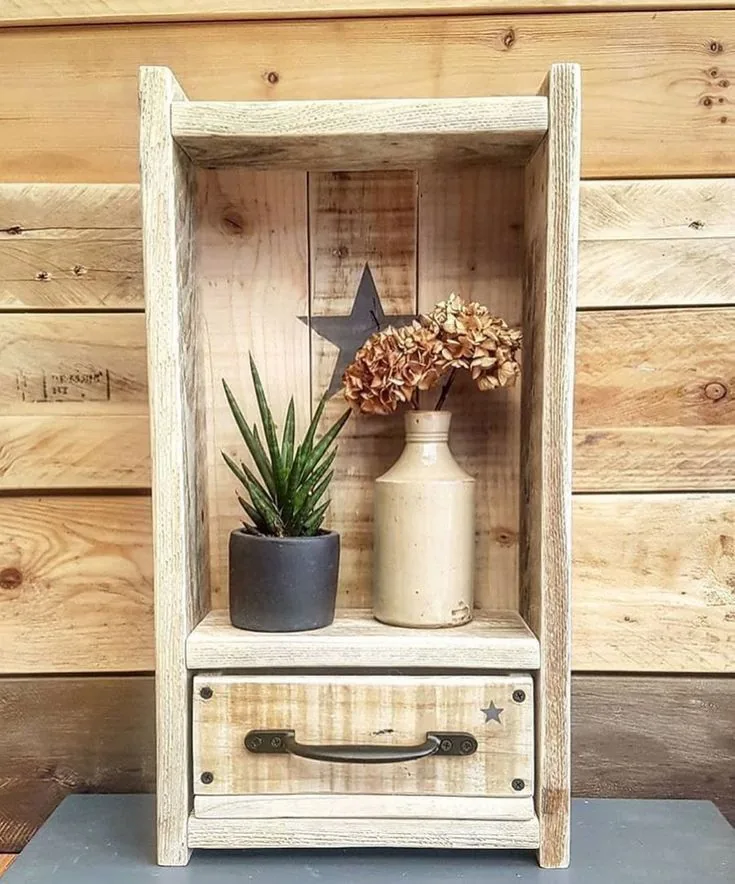 Vitrina de tablas en tono claro con una planta, un jarrón y un cajón con manija